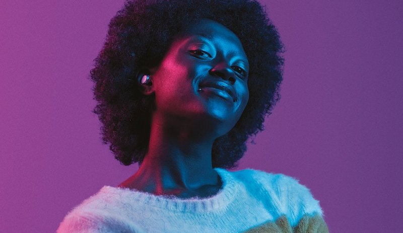 Eine afroamerikanische Frau mit Signia Active Hörgeräten im Ohr